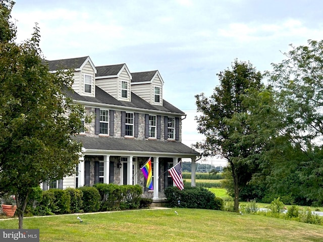 view of front facade featuring covered porch and a front yard