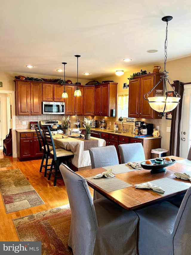 dining space featuring light hardwood / wood-style flooring and sink