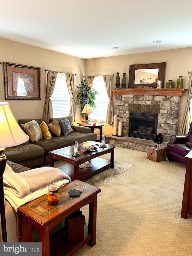 living room featuring a stone fireplace and carpet floors