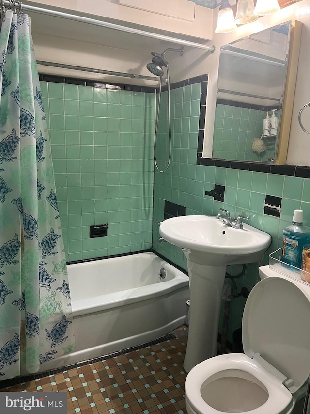 bathroom with tile patterned flooring, toilet, decorative backsplash, shower / tub combo with curtain, and tile walls