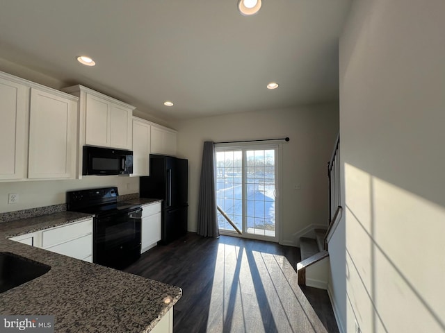 kitchen featuring black appliances, dark wood-type flooring, white cabinetry, and dark stone countertops