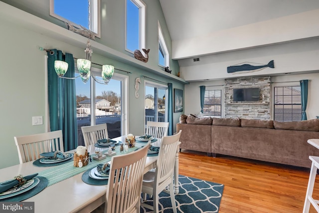 dining room with a high ceiling, an inviting chandelier, and hardwood / wood-style floors