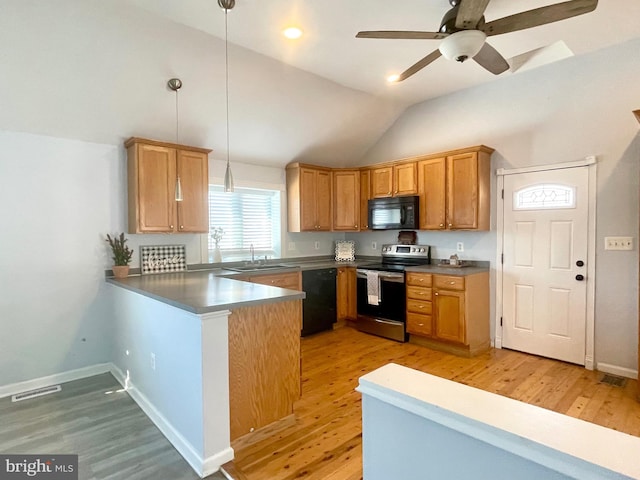 kitchen with lofted ceiling, black appliances, sink, decorative light fixtures, and kitchen peninsula