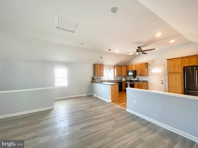 kitchen featuring ceiling fan, pendant lighting, vaulted ceiling, appliances with stainless steel finishes, and light wood-type flooring