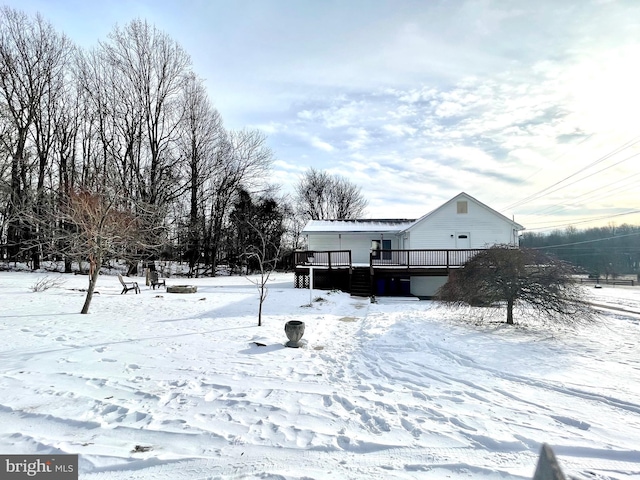 yard covered in snow featuring a deck