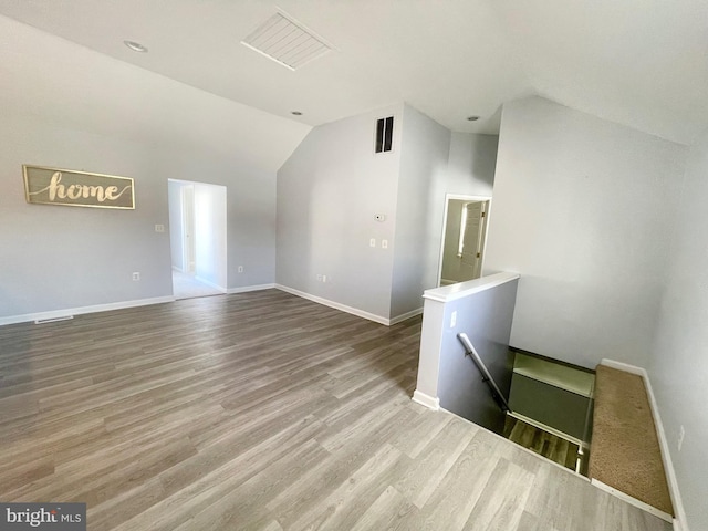 unfurnished living room featuring hardwood / wood-style floors and lofted ceiling