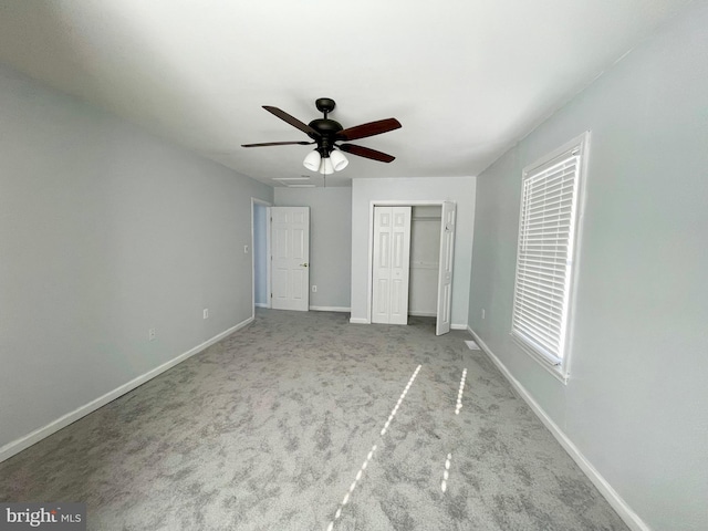 unfurnished bedroom featuring light colored carpet and ceiling fan