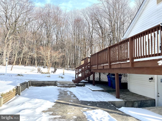 yard covered in snow with a wooden deck