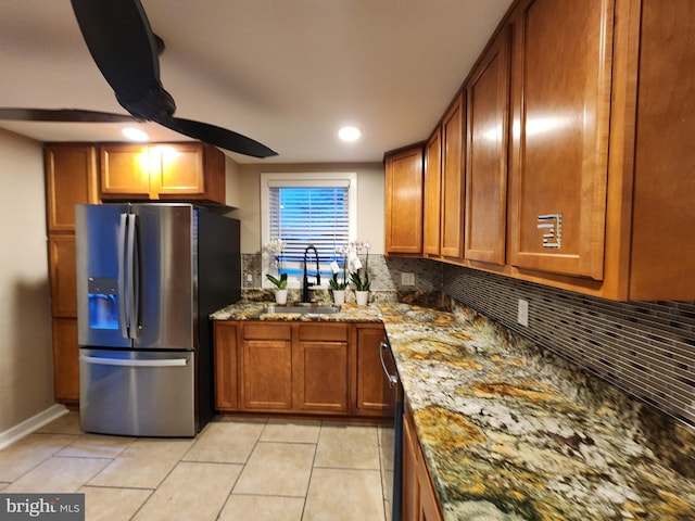 kitchen featuring light stone counters, light tile patterned floors, sink, and appliances with stainless steel finishes