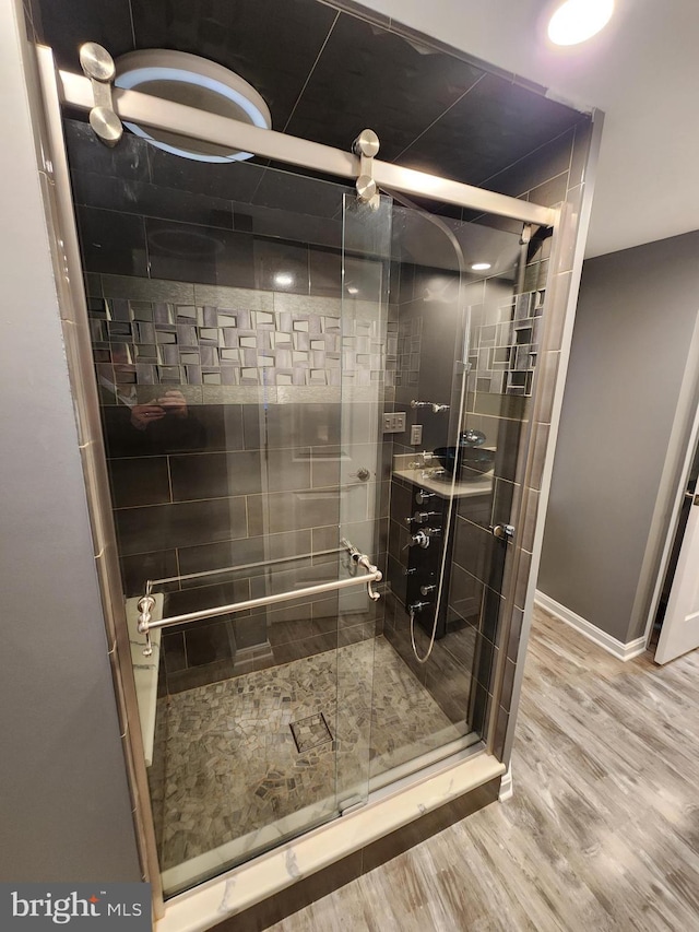 bathroom with wood-type flooring and walk in shower