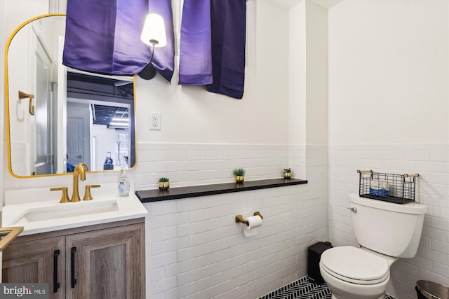 bathroom featuring tile walls, toilet, and vanity