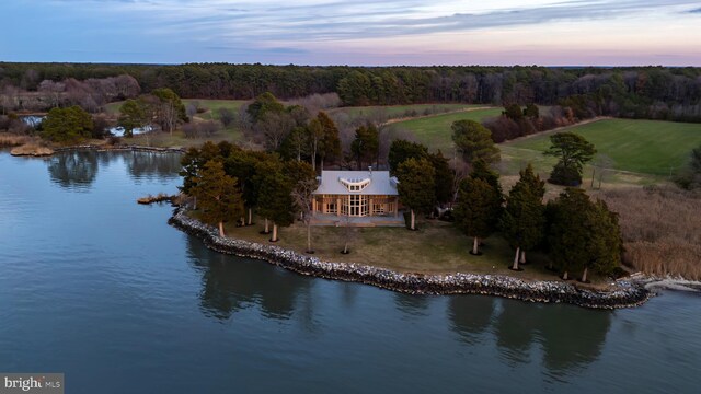 aerial view at dusk featuring a water view