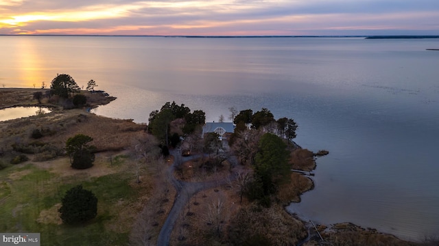 aerial view at dusk featuring a water view