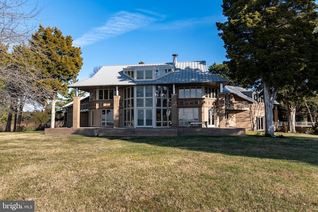 rear view of property with a sunroom and a yard