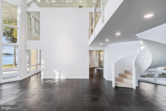 interior space with a towering ceiling and a water view