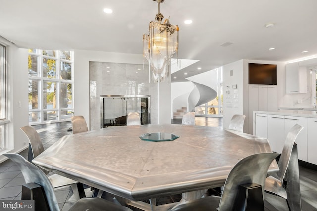 dining room with tile patterned floors, an inviting chandelier, and expansive windows