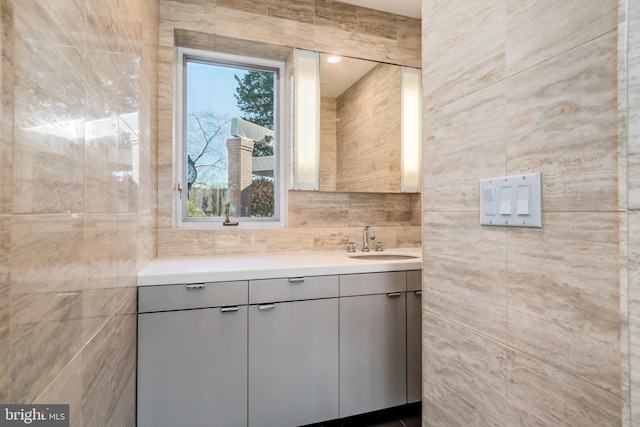 bathroom with vanity and tile walls