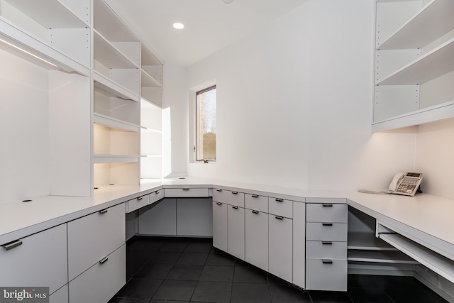 unfurnished office featuring dark tile patterned floors