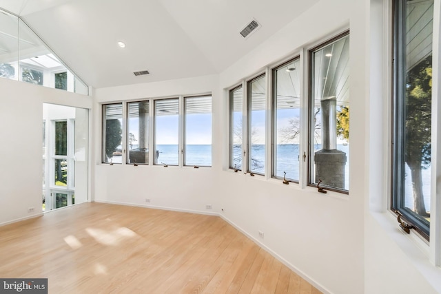 unfurnished sunroom featuring a water view and lofted ceiling