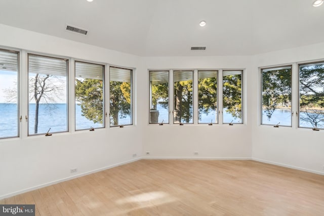 unfurnished sunroom featuring a water view and a wealth of natural light