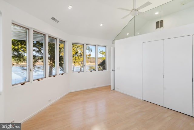 unfurnished bedroom with ceiling fan, lofted ceiling, and light wood-type flooring