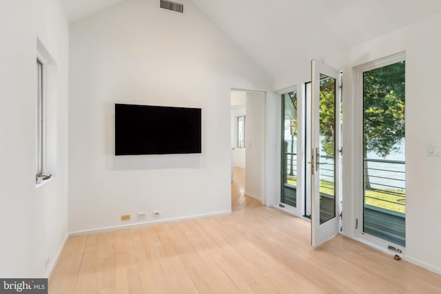 unfurnished living room featuring lofted ceiling and light hardwood / wood-style flooring