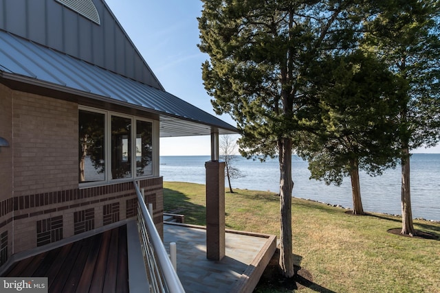 deck with a lawn and a water view