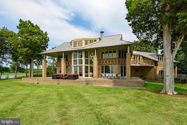 back of house with an outdoor living space, a balcony, a patio area, and a lawn