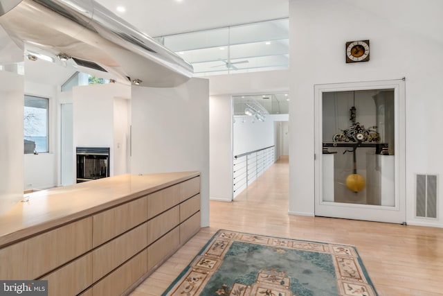 kitchen with ceiling fan, light wood-type flooring, and lofted ceiling