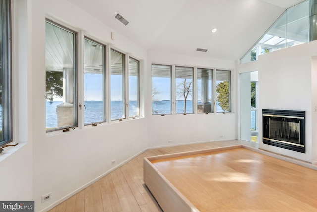 sunroom / solarium with a water view and vaulted ceiling