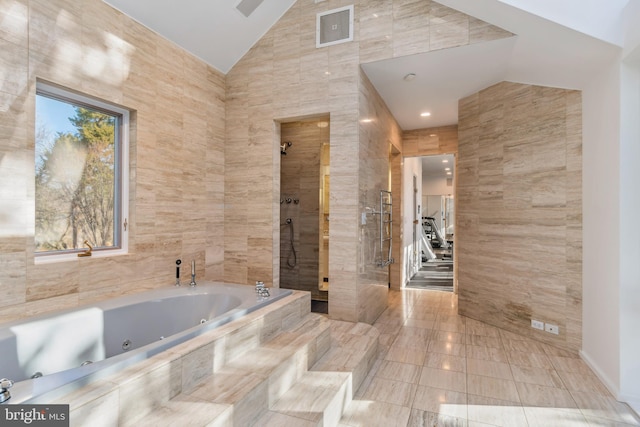 bathroom with vaulted ceiling, separate shower and tub, and tile walls