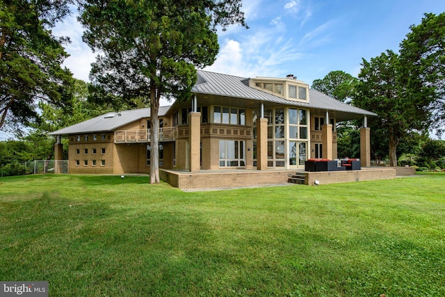 rear view of property featuring a lawn and an outdoor living space