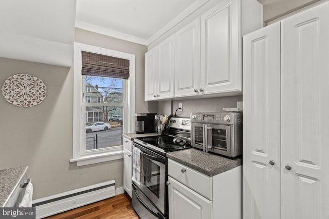 kitchen featuring white cabinetry, hardwood / wood-style floors, stainless steel range with electric cooktop, and a baseboard heating unit