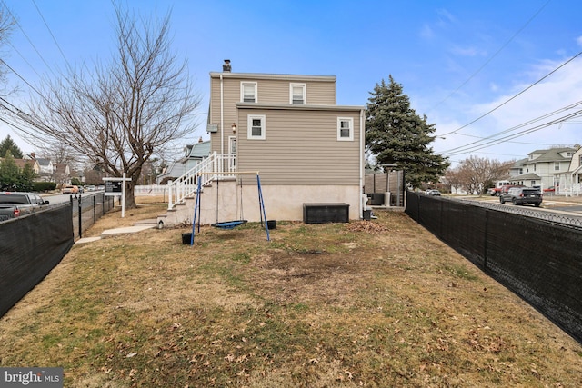 back of house with a lawn