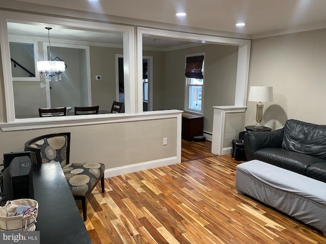 living room with hardwood / wood-style flooring, baseboard heating, and crown molding