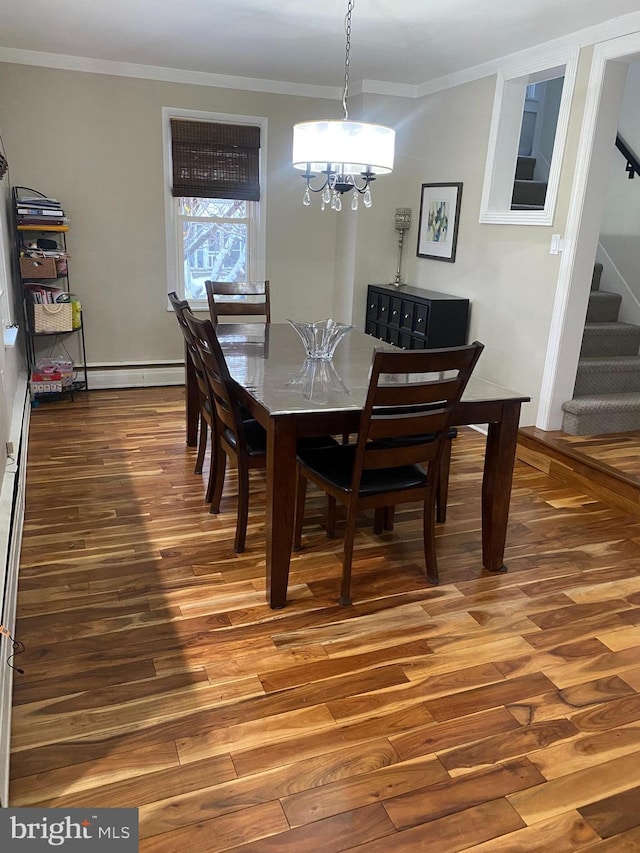 dining room with wood-type flooring, a baseboard radiator, crown molding, and a notable chandelier