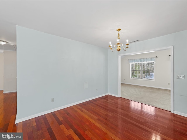 unfurnished room featuring hardwood / wood-style floors and a notable chandelier