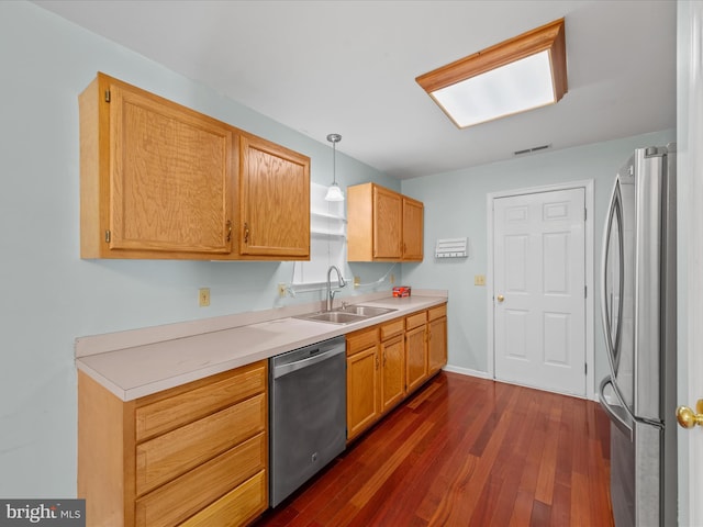 kitchen with dark hardwood / wood-style flooring, sink, hanging light fixtures, and appliances with stainless steel finishes