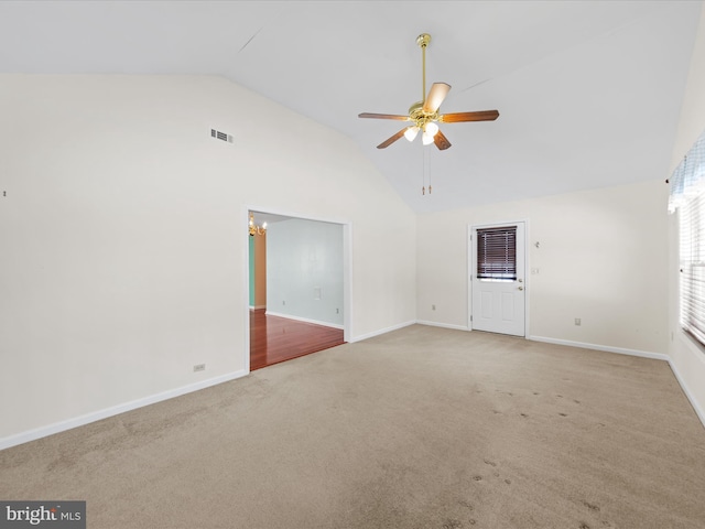 carpeted empty room with vaulted ceiling and ceiling fan with notable chandelier