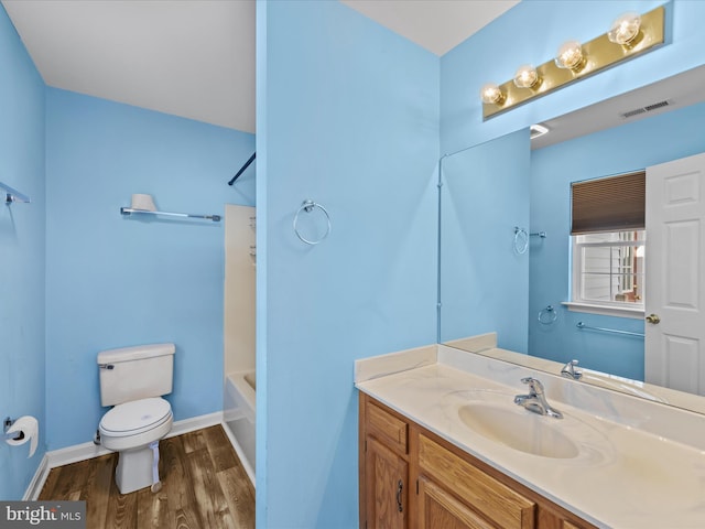 full bathroom featuring wood-type flooring, vanity, shower / bath combination, and toilet