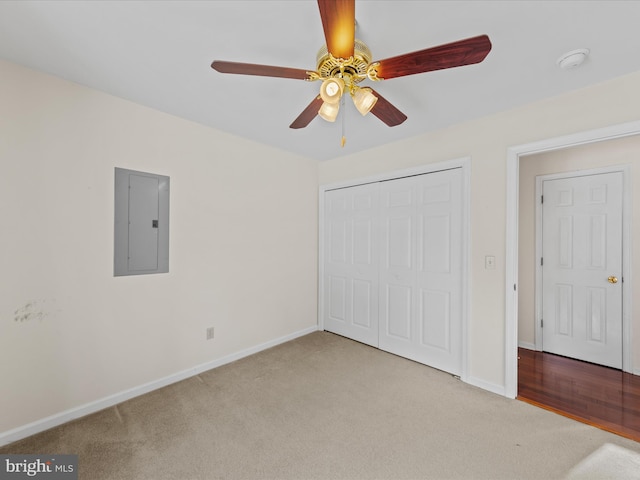 unfurnished bedroom with ceiling fan, light colored carpet, electric panel, and a closet