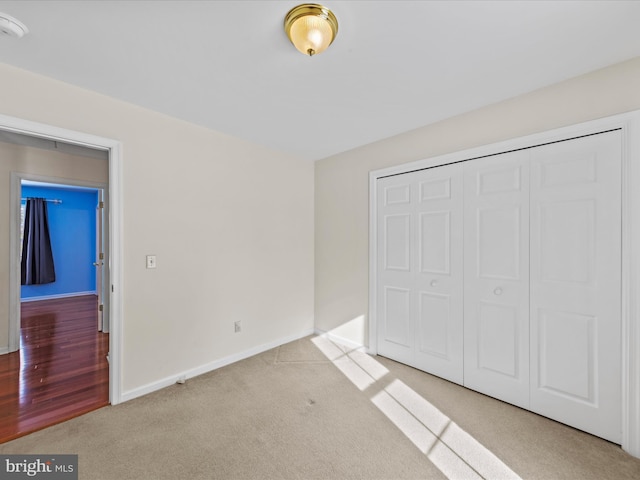 unfurnished bedroom with light carpet and a closet