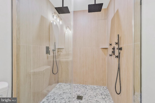 bathroom with tiled shower and toilet