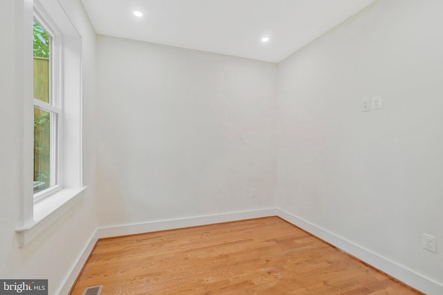 unfurnished room with a healthy amount of sunlight and light hardwood / wood-style floors