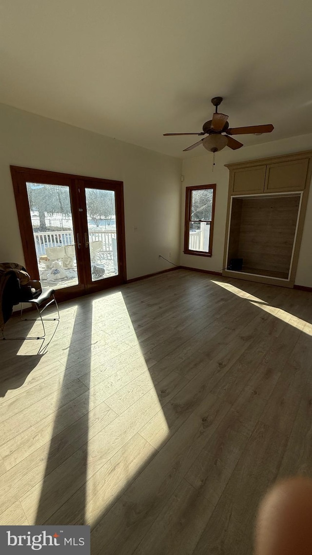 interior space with a healthy amount of sunlight, ceiling fan, and light wood-type flooring