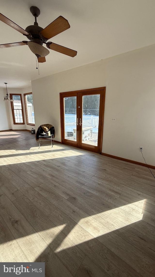 unfurnished room featuring french doors, ceiling fan, and light wood-type flooring