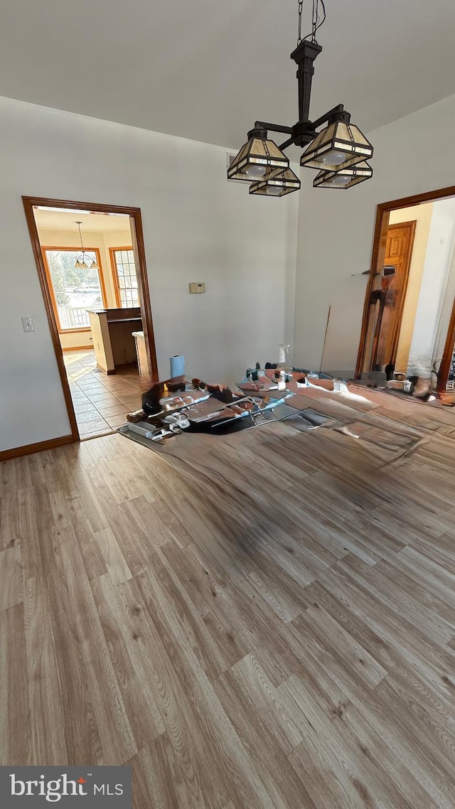 unfurnished dining area featuring light hardwood / wood-style floors and a chandelier