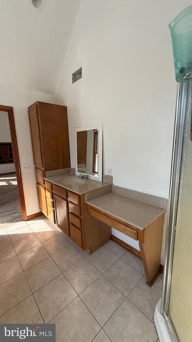 interior space featuring tile patterned flooring, high vaulted ceiling, and vanity