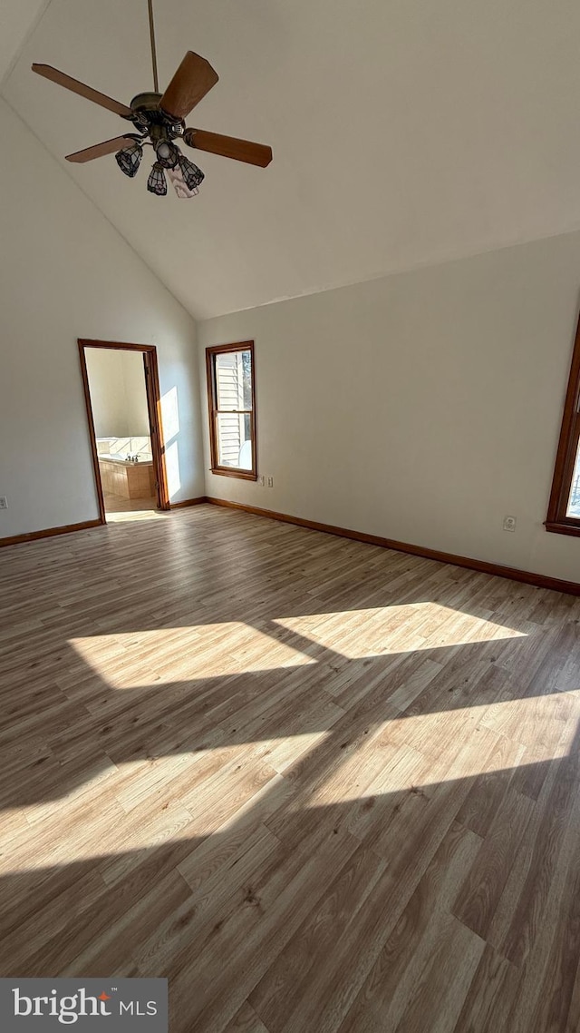 spare room with ceiling fan, light wood-type flooring, and high vaulted ceiling