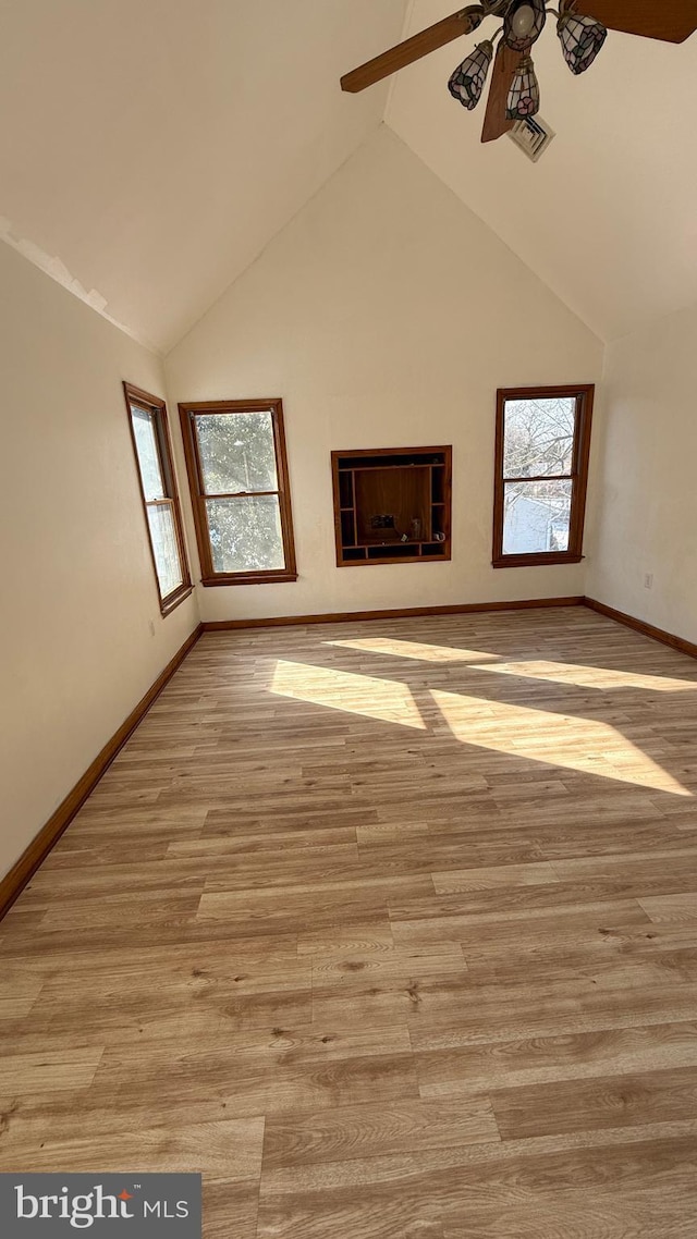 unfurnished living room with ceiling fan, light hardwood / wood-style flooring, lofted ceiling, and plenty of natural light